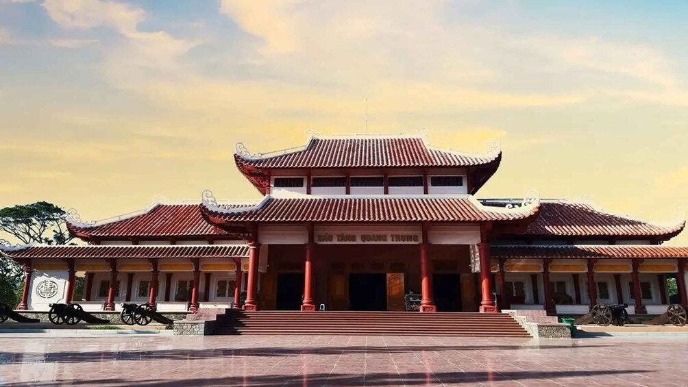 A traditional Chinese building with a multi-tiered roof and red columns. 5