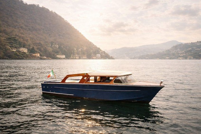 A boat on calm water with a mountainous landscape in the background. 1
