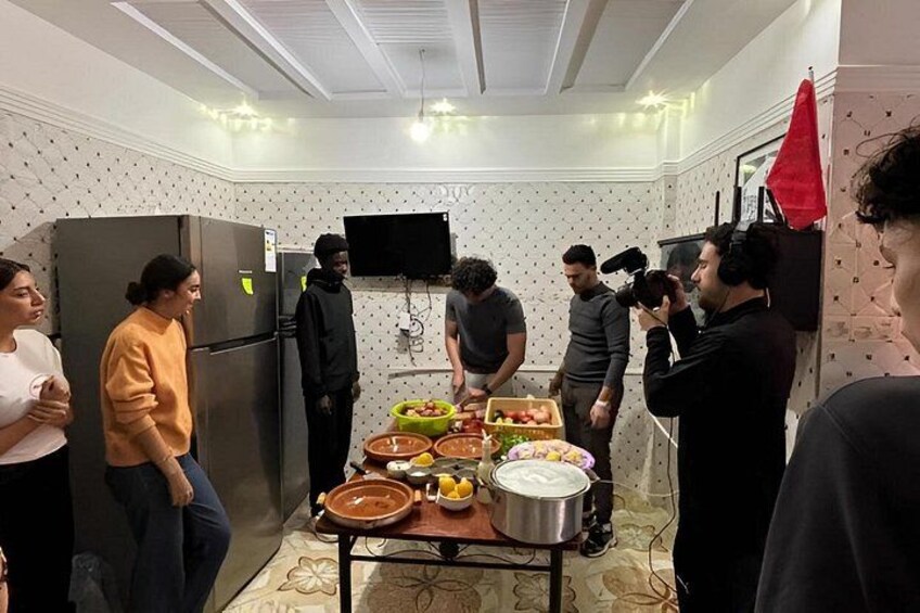 A group of people in a kitchen with food on the table. 3