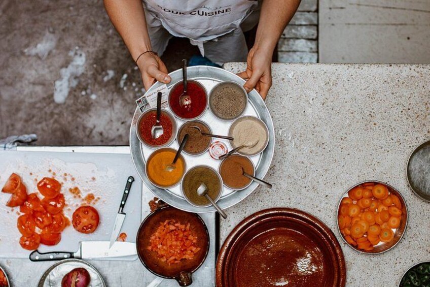 A person holding a metal plate with various food items. 2