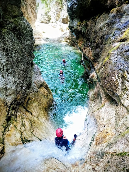 A river flowing through a rocky gorge with people engaged in water activities. 5