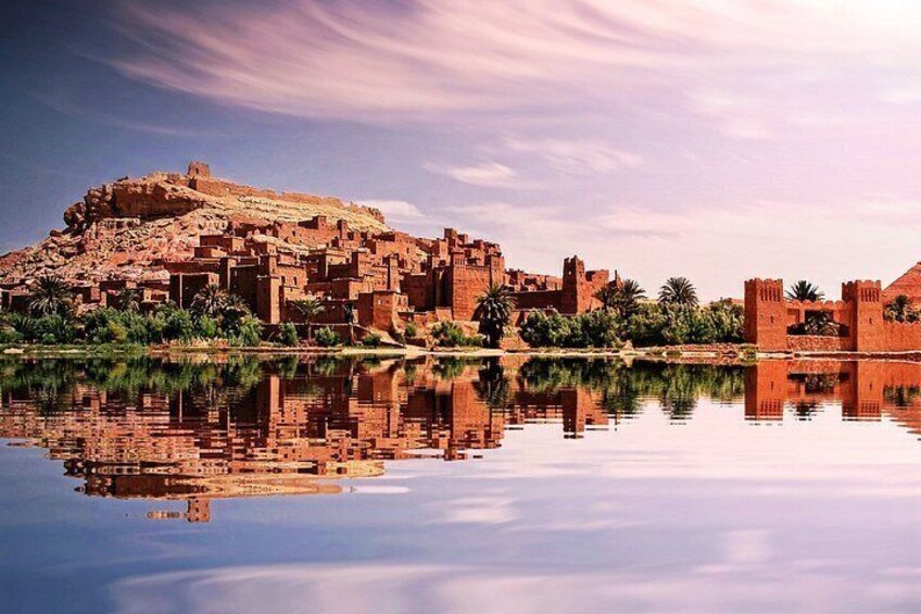 A historic city with ancient architecture by a calm body of water. 4