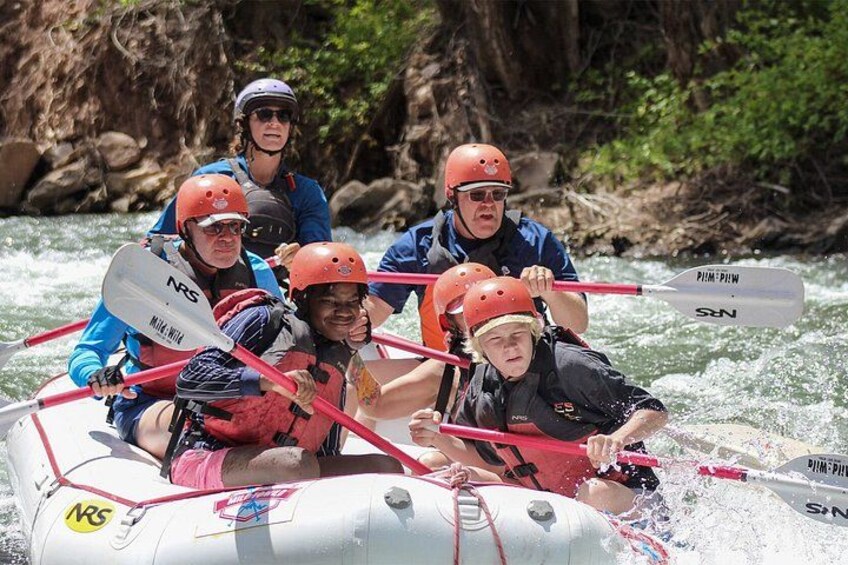 A group of people in a raft navigating a river. 2