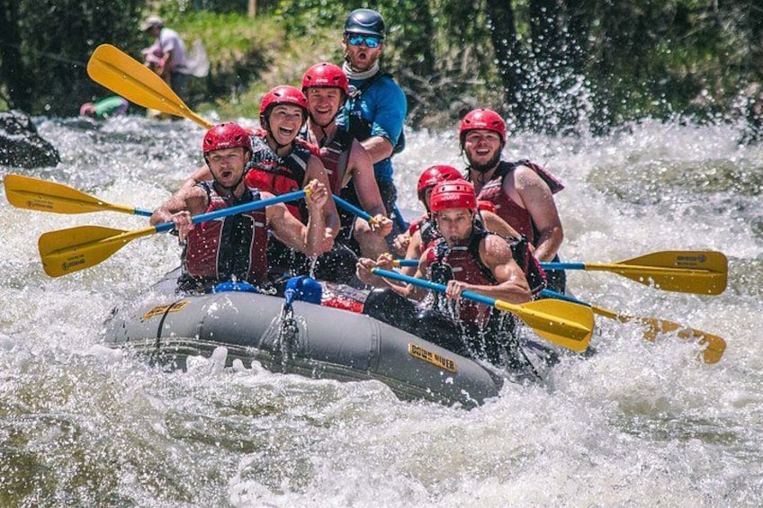 A group of people in a raft navigating a river. 1