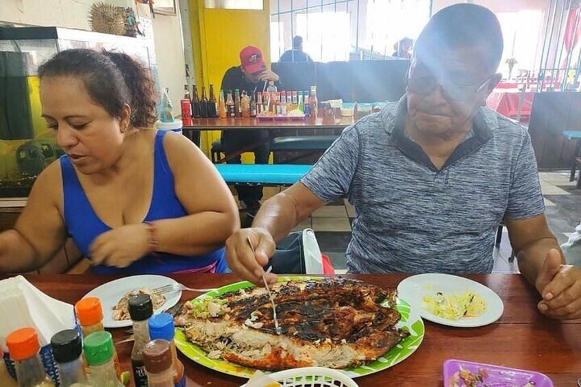 Une personne qui découpe une grande portion de viande grillée à la table d’un restaurant. 2