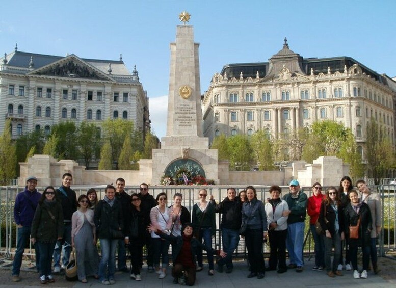 A group of people standing in front of a monument with a star on top, surrounded by classical architecture. 1
