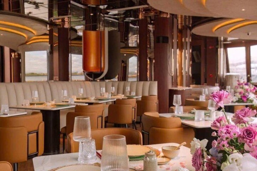 Un restaurante con cabinas de cuero, mesas redondas y vistas al mar. 1