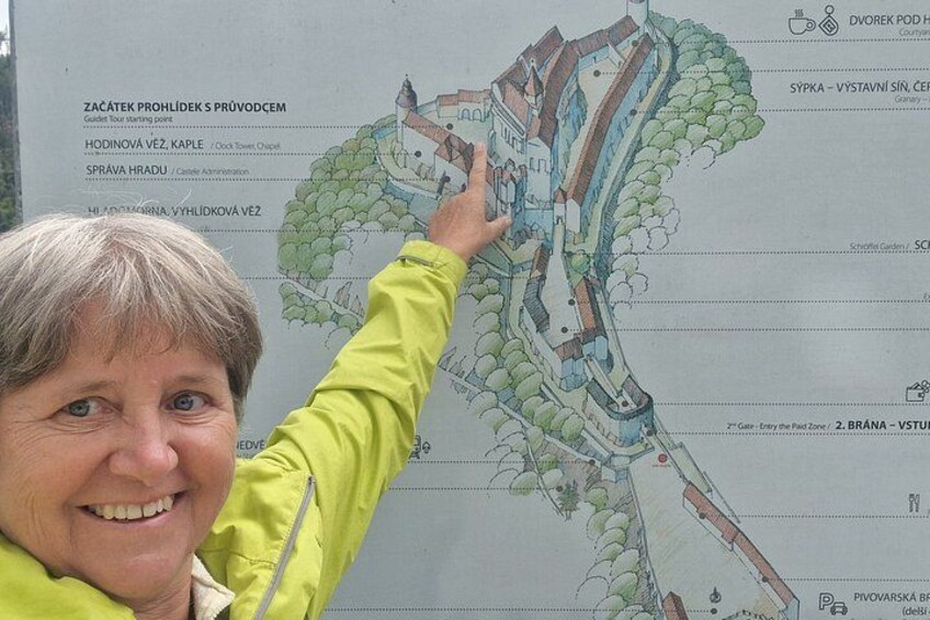 A person pointing at a detailed map of a castle complex. 2