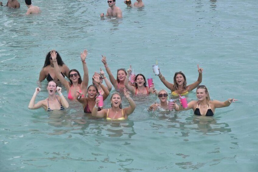 Un grupo de personas en una piscina, algunas sosteniendo bebidas. 3