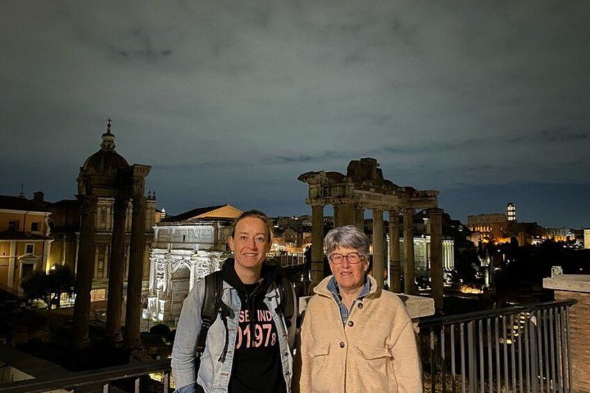 Deux personnes se tiennent devant des ruines antiques, de nuit. 2