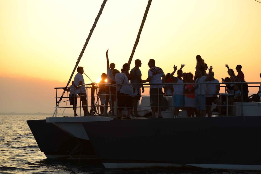 A group of people on a boat at sunset. 5
