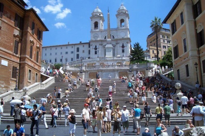 A crowded staircase leading to a historic church with two bell towers. 3