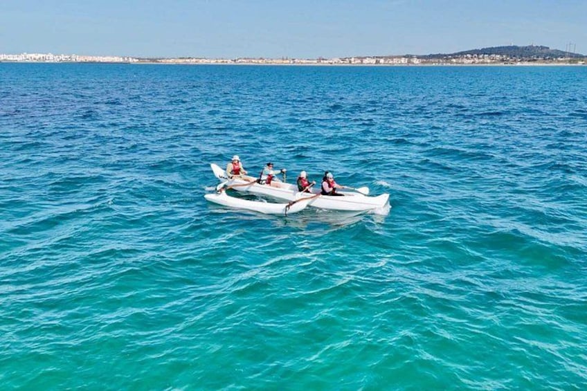 A small white boat with three people on a calm sea. 3