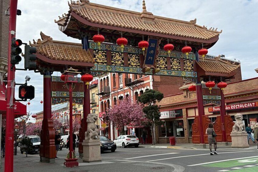 A traditional Chinese gate with red lanterns, a restaurant, and a traffic light. 2