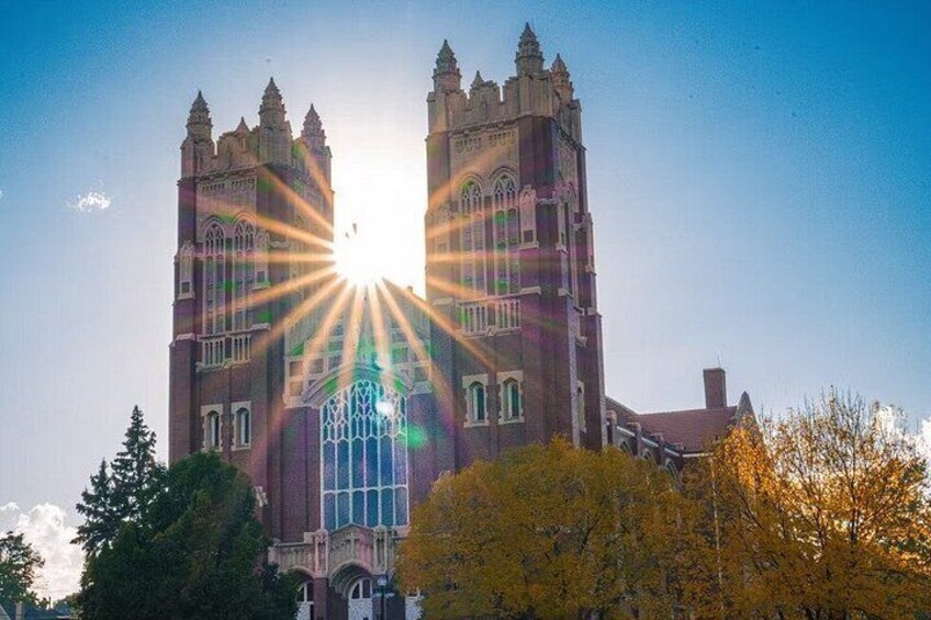 A Gothic-style building with twin towers and arched windows, with sunlight streaming through. 2