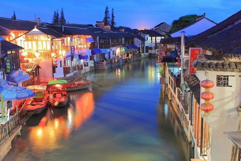 Ein Fluss mit Booten, traditionellen Gebäuden und roten Laternen am Ufer. 1