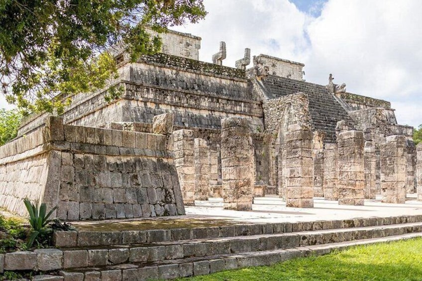 Una antigua pirámide maya con escalones de piedra y una muralla que la rodea. 5