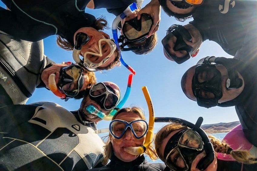 A group of people wearing scuba diving masks and snorkels, gathered together. 3