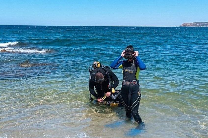 Two scuba divers preparing to enter the water. 5
