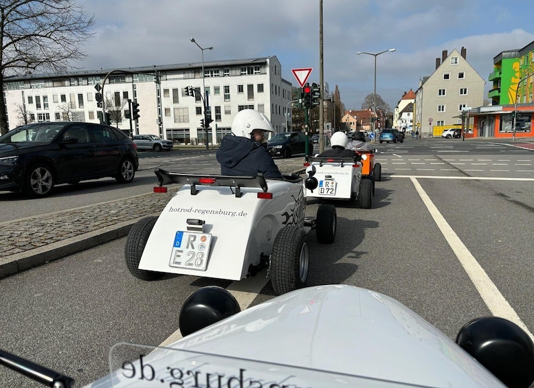 A street with a white car and a small vehicle with a license plate. 3