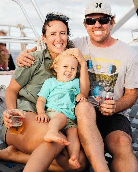 Eine Familie auf einem Boot: ein Kind in der Mitte, eine erwachsene Person links und eine rechts. 2