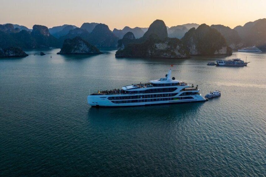 Un grand navire de croisière dans une baie paisible, avec des îles montagneuses en arrière-plan. 1