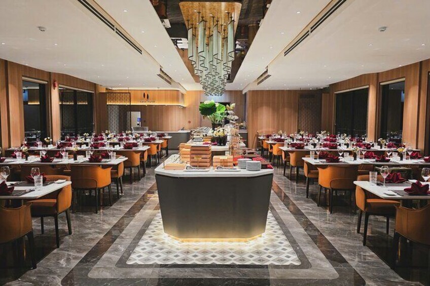 Un restaurant moderne doté d’un bar central, de plusieurs tables et d’une pièce maîtresse décorative. 4