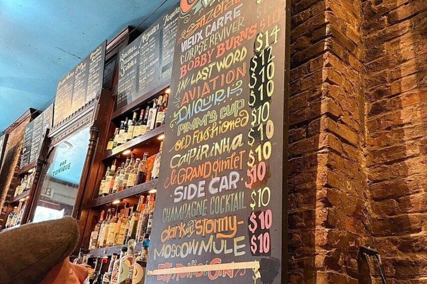 Un bar dont le menu, écrit à la craie sur un tableau noir, indique les boissons proposées et leurs prix. 5