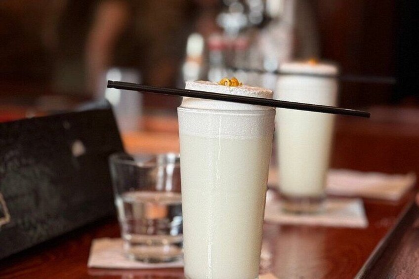 Deux grands verres remplis d’une boisson crémeuse, chacun agrémenté d’une paille noire, sont posés sur une table en bois, avec un arrière-plan flou. 2