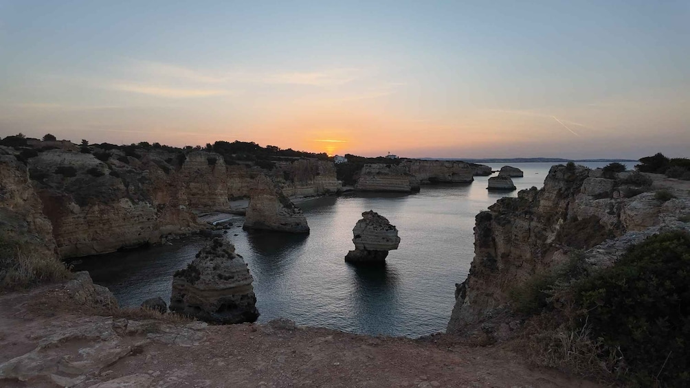 A coastal landscape with rock formations and a sunset. 3