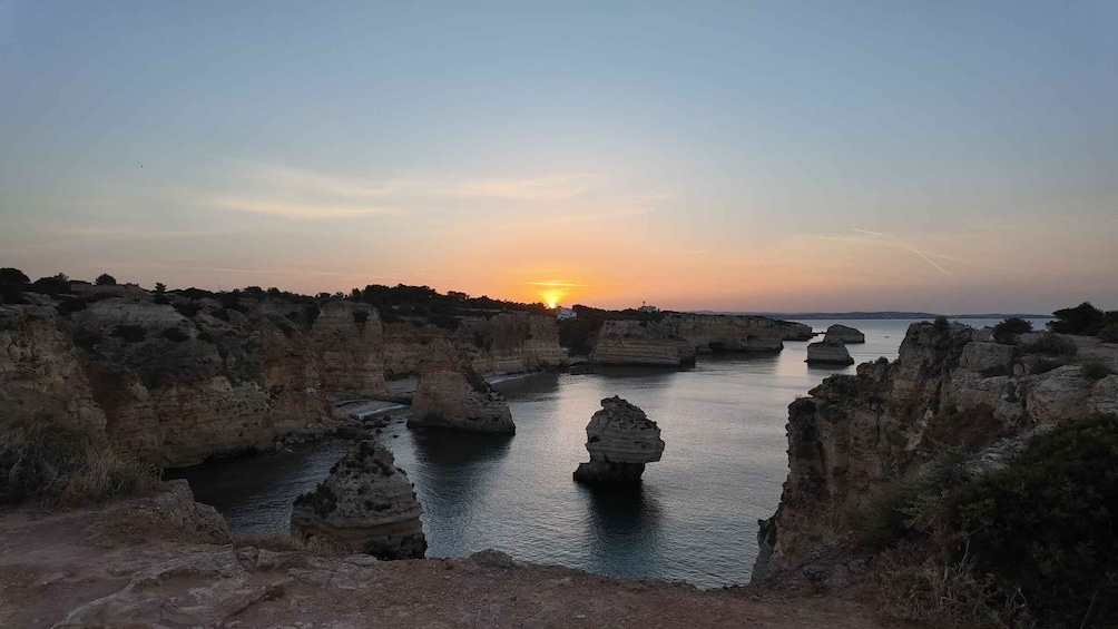 A coastal landscape with rock formations and a sunset. 2
