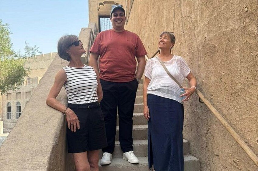 Tres personas de pie sobre una escalera de piedra con un edificio al fondo. 4