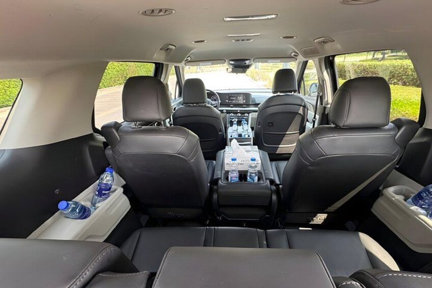 Interior de coche con asientos de cuero negro, una consola central y vista trasera del tablero. 2