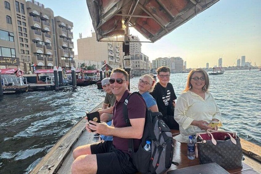 Un grupo de personas en un bote, con un paisaje urbano y agua de fondo. 1