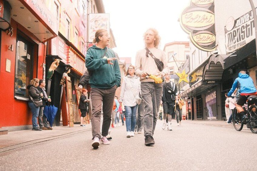 A busy urban street with pedestrians, shops, and a cyclist. 3