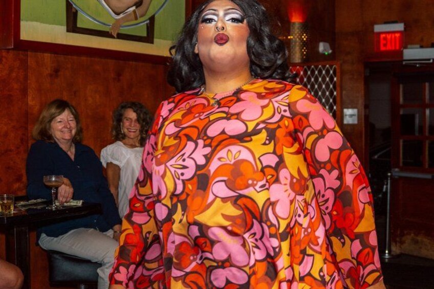 A person in a colorful floral dress, an exit sign, and a wooden wall. 4
