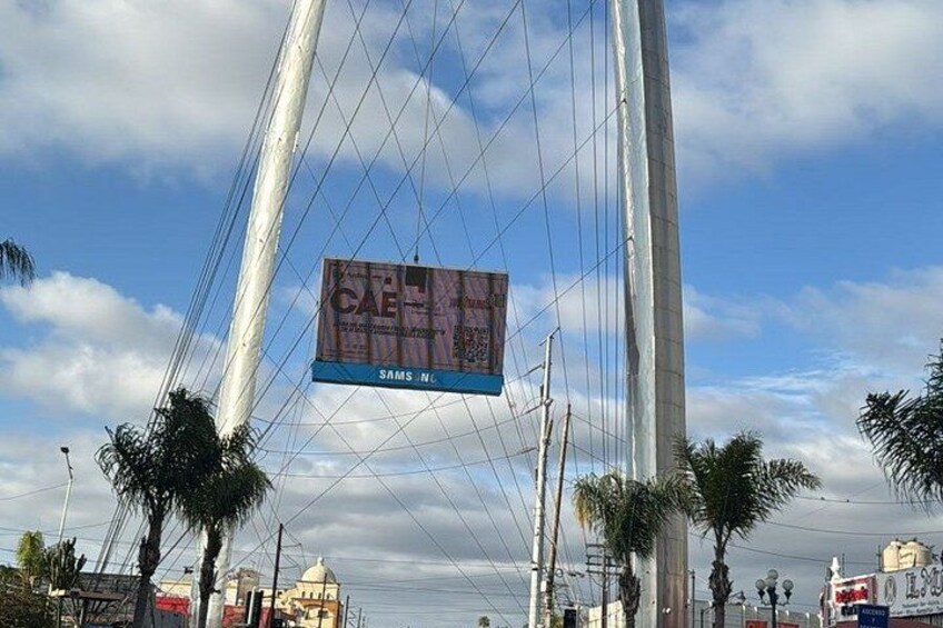 Un pont à haubans sur lequel est installé un grand panneau publicitaire pour un café. 1