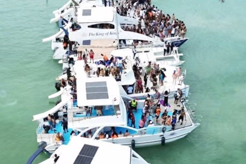 A fleet of boats docked in a marina with people on board. 5