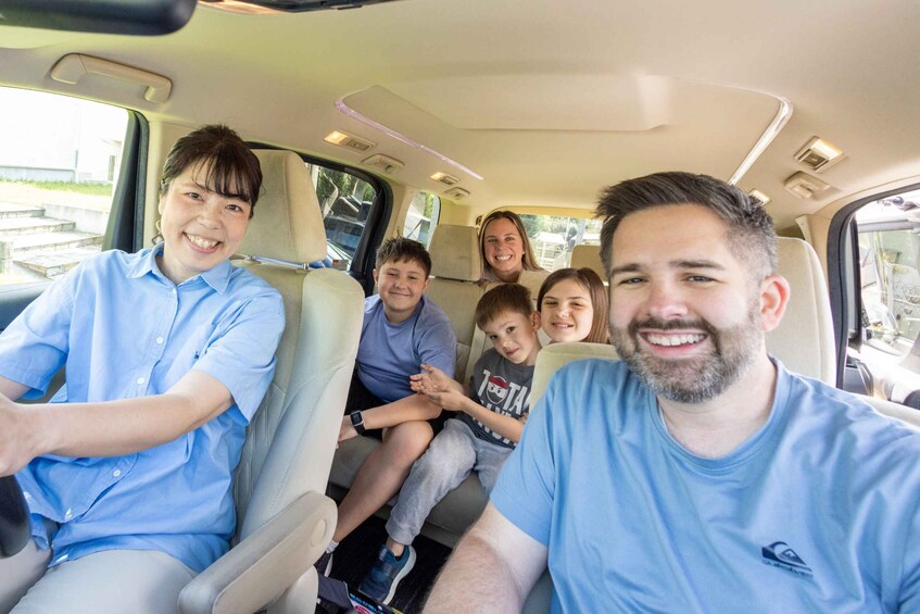 A family inside a car with beige seats and a sunroof. 1