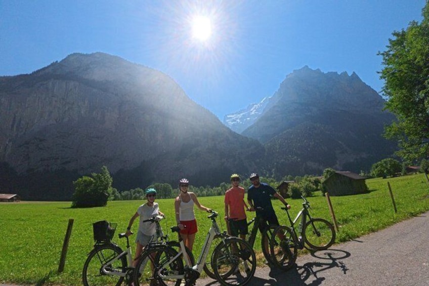 A group of cyclists on a path with mountains in the background. 3