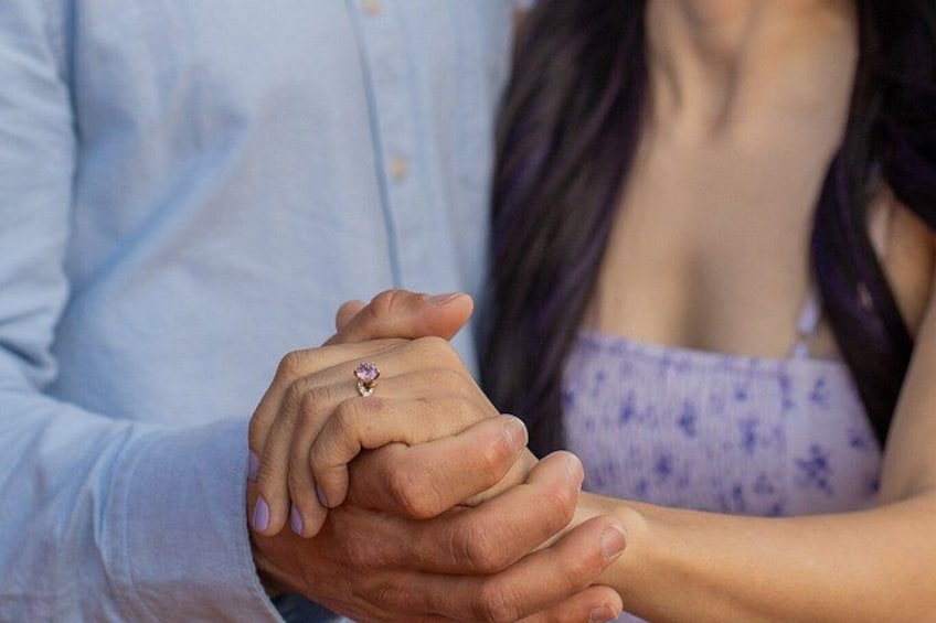 A person wearing a light blue shirt holding hands with another person wearing a purple floral top. 2