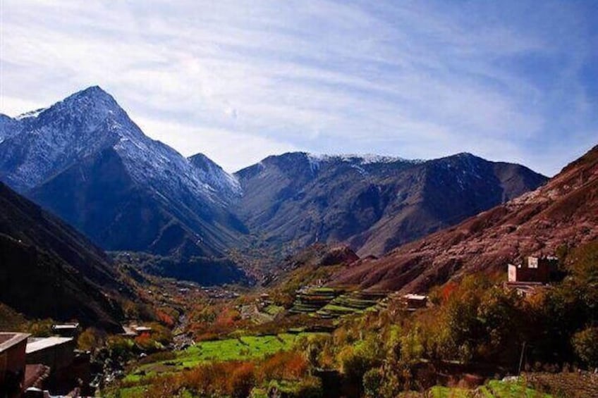 A mountainous valley with terraced fields and a prominent peak. 1