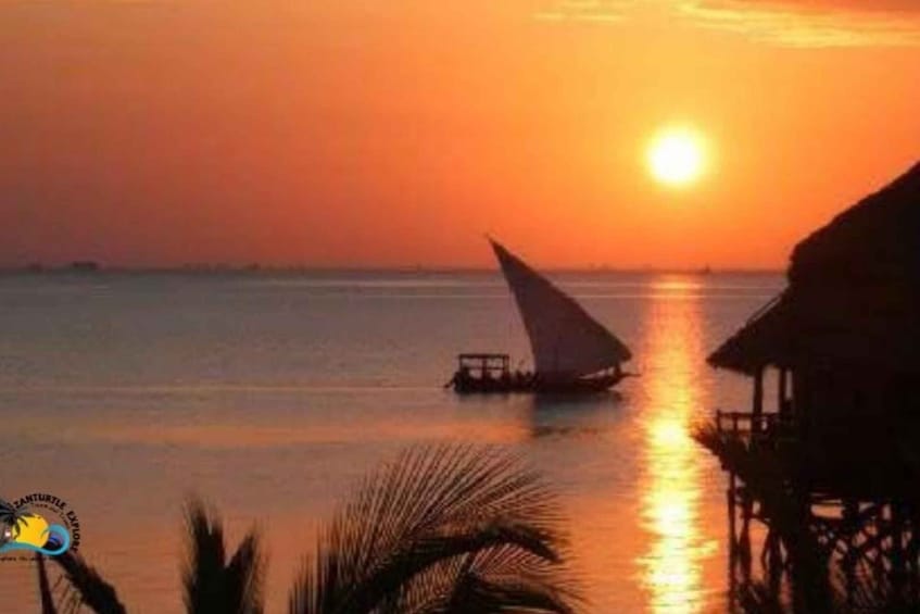 A sunset over a calm sea with a sailboat and overwater structures. 5