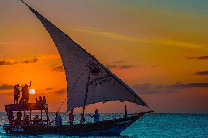 A boat with people on board during sunset. 1