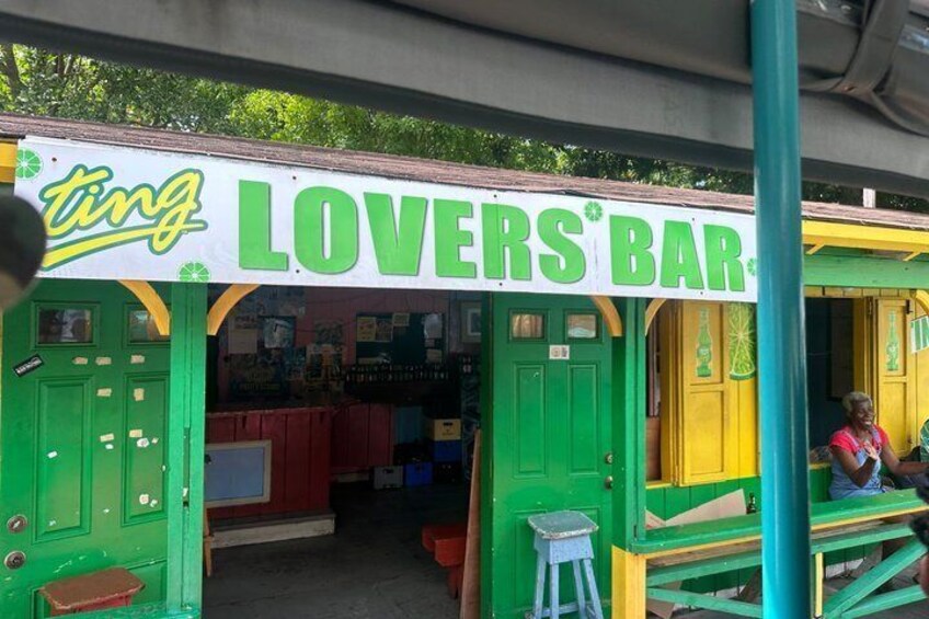 A colorful bar named 'Lovers' Bar' with green and yellow accents and a sign that reads 'ting.' 1
