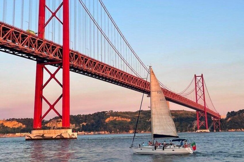 Una barca a vela su un fiume, sullo sfondo un ponte rosso imponente. 1
