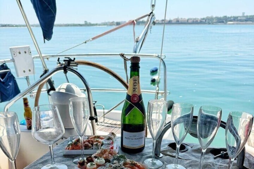 A bottle of Moët & Chandon champagne, empty glasses, and a plate of food on a boat. 3