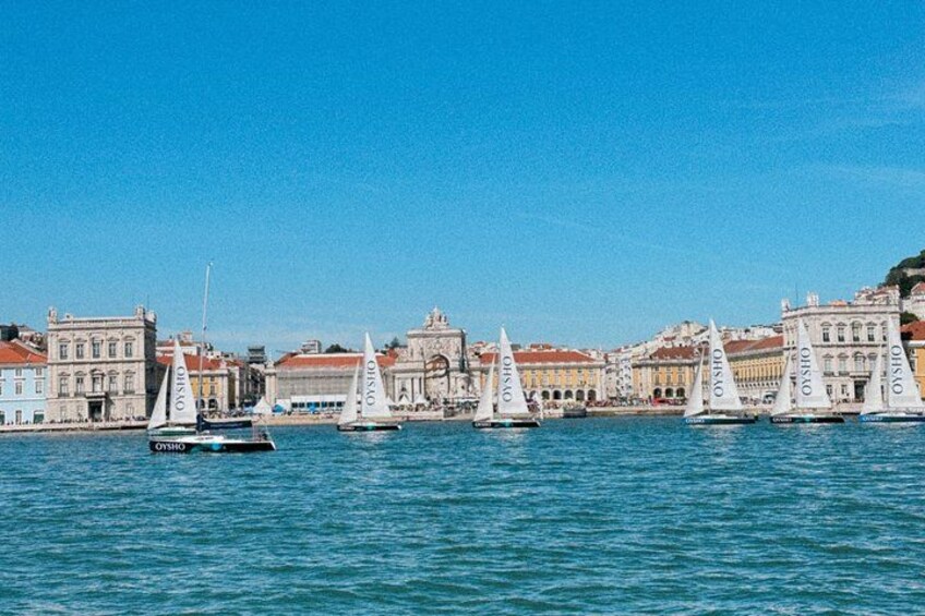 Vele su un mare calmo, con edifici sullo sfondo. 5
