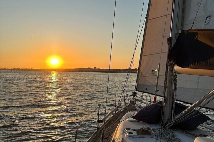 A sailboat at sunset with the sun reflecting on the water. 4