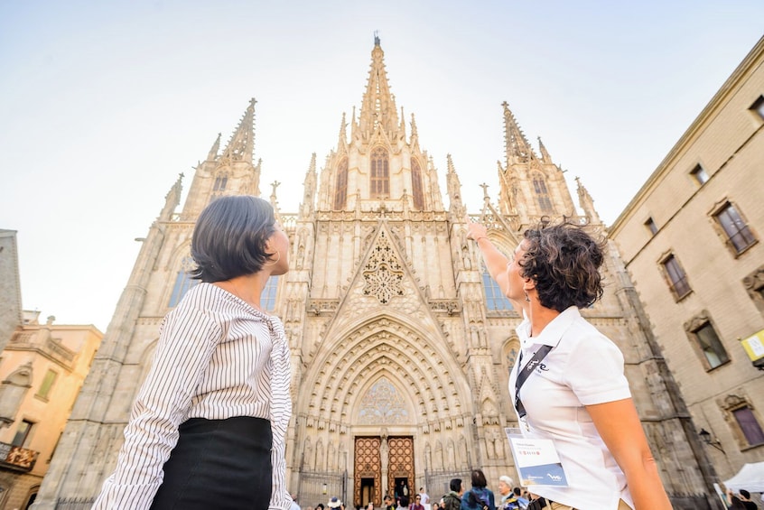 Two people in front of a large Gothic cathedral with intricate spires and detailed architecture. 5